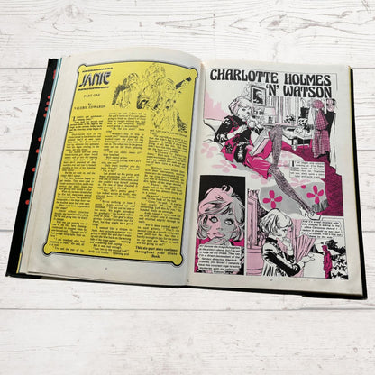 Open book with comic book-style illustrations and text on a wooden surface