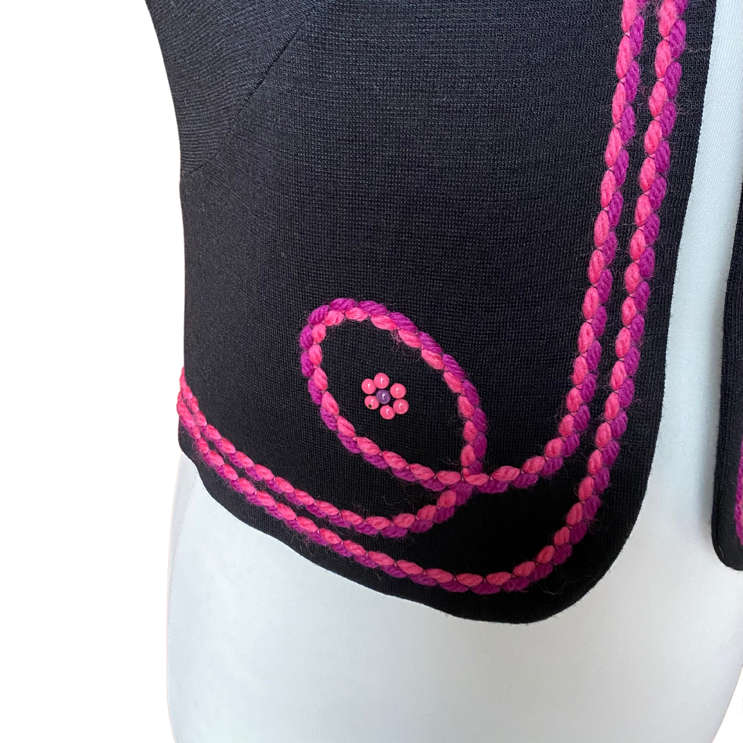 A classic 70s waistcoat in black, enhanced with striking pink and purple embroidery and ornate beaded flowers. Tiny paint chip 