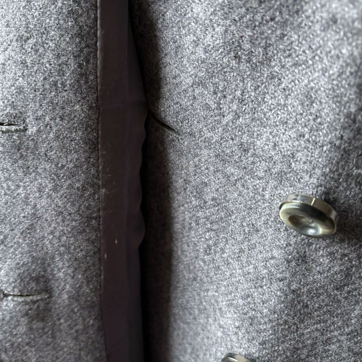 Close-up of a textured gray fabric with a button 