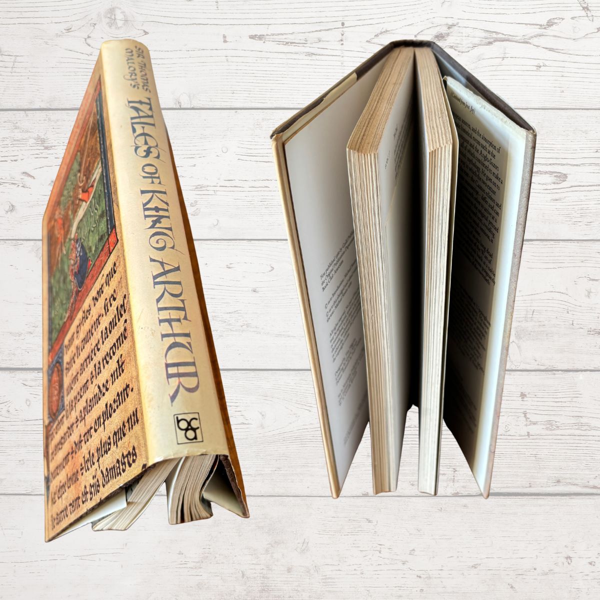 Decorative book titled 'Tales  of King Arthur' on a wooden surface
