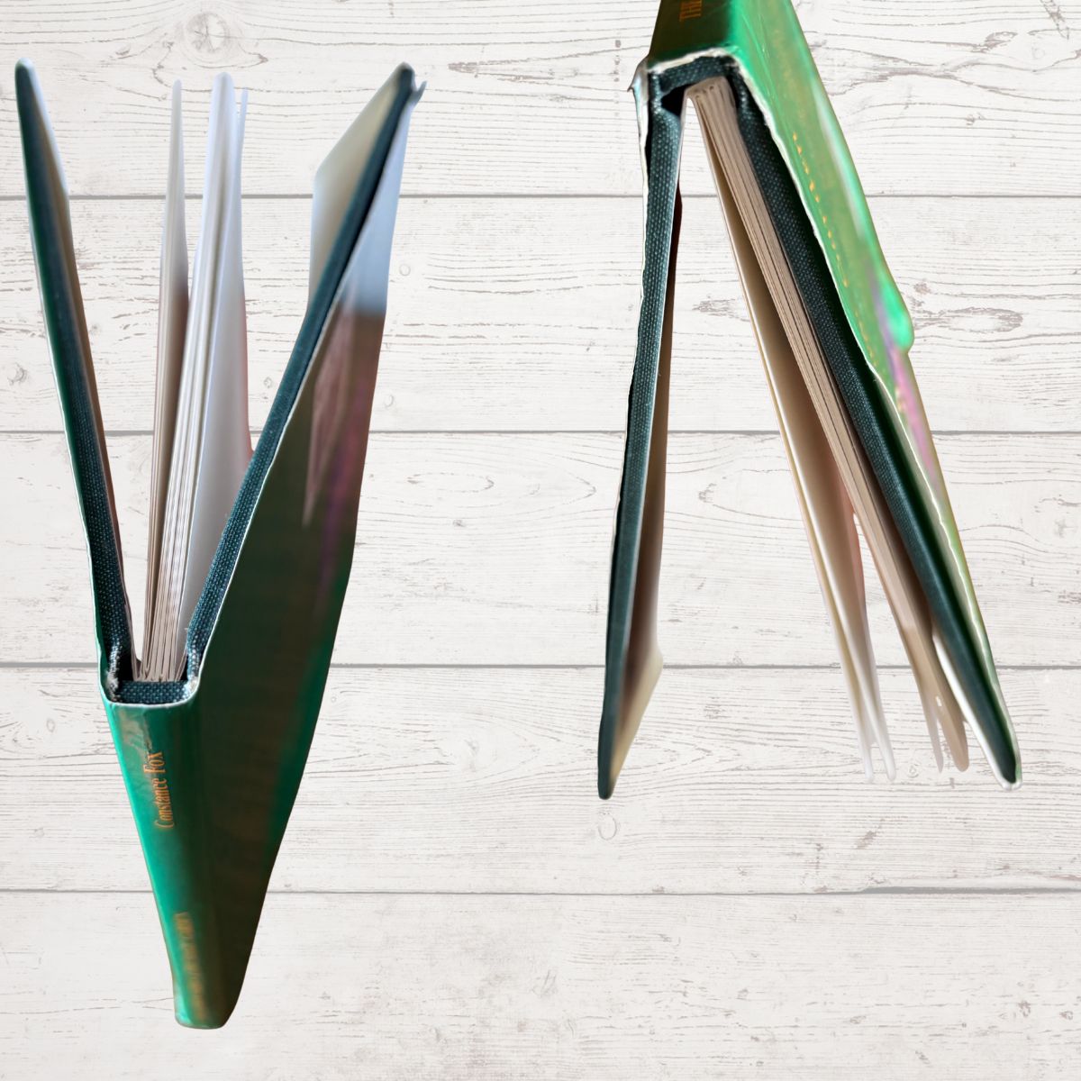  green book spines on a light wooden surface