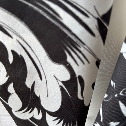 Close-up of a black and white patterned fabric with a visible brand logo.