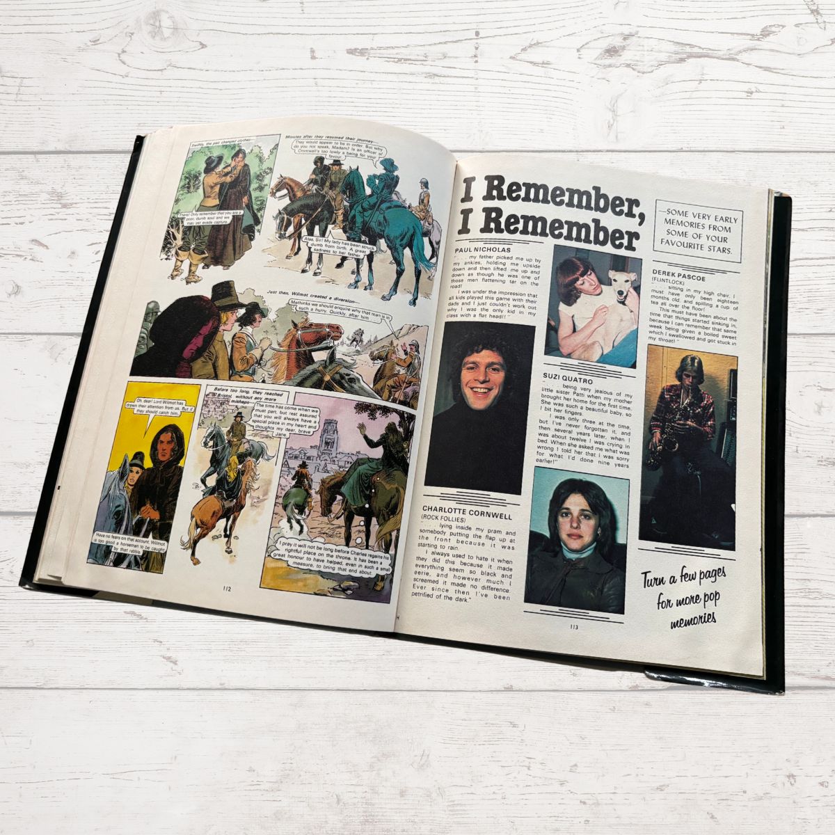 Open book with illustrations of people and horses on a wooden surface