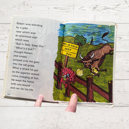 Open book with a cartoon illustration of a bull and text on a wooden surface
