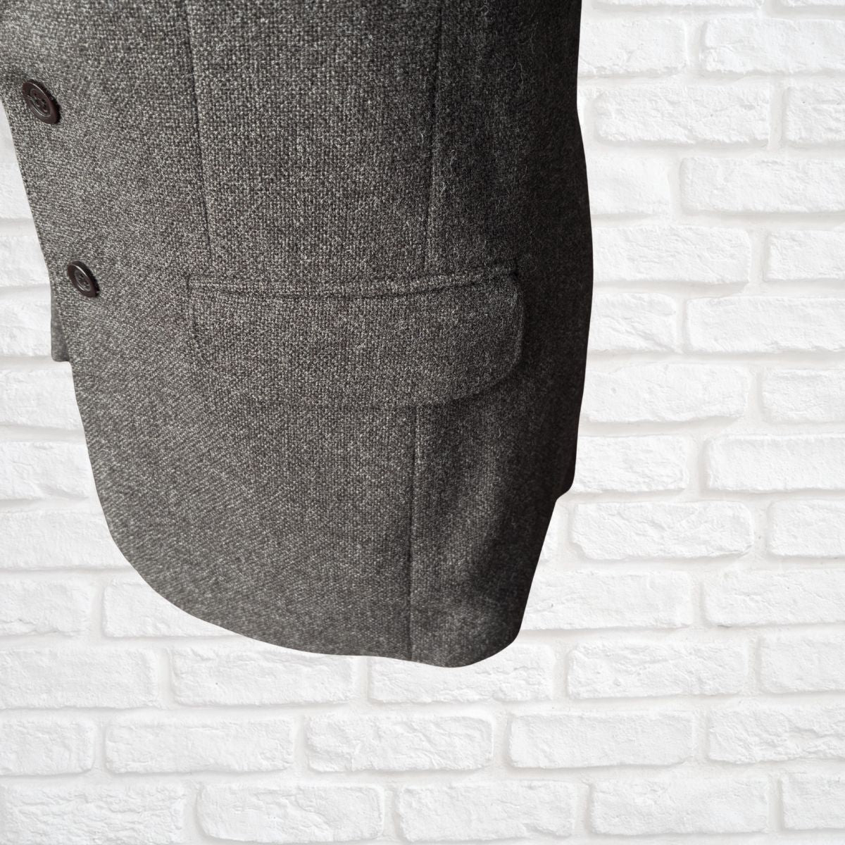 Brown textured coat on a white brick wall background