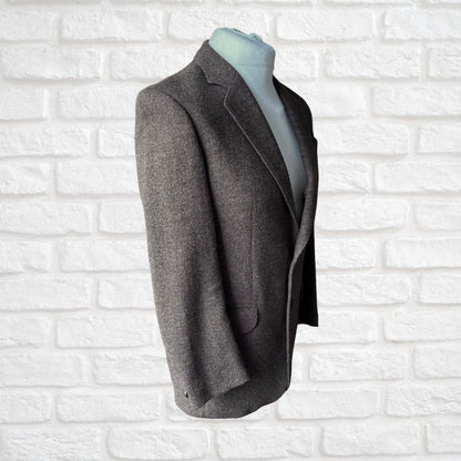 Brown  blazer on a mannequin against a white brick wall background