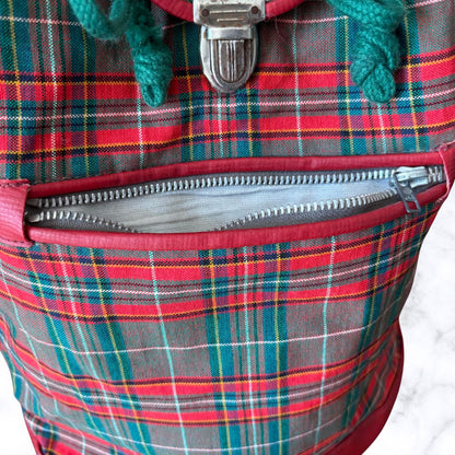 Close-up of a plaid bag with a zipper, showing red, green, and blue colors.