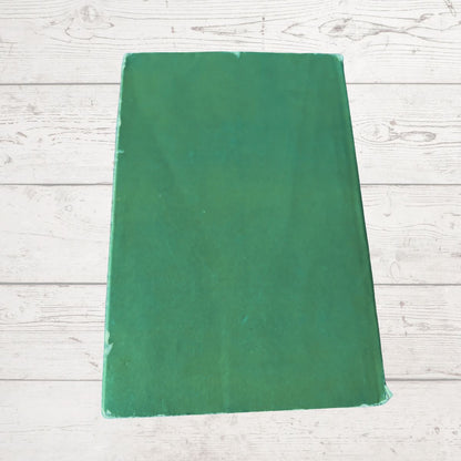 Green book cover  on a light wooden surface