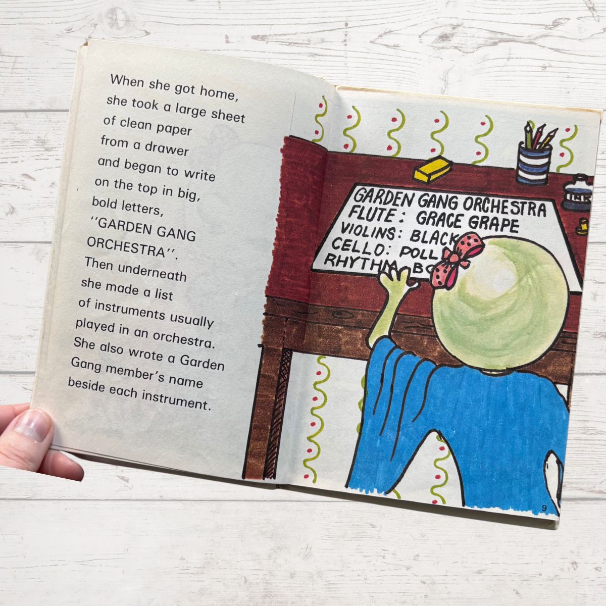 Open book with illustrated page and text on a wooden surface