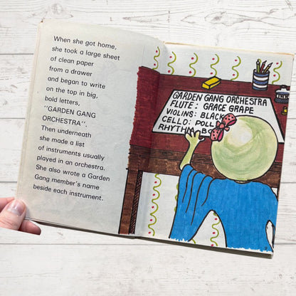 Open book with illustrated page and text on a wooden surface