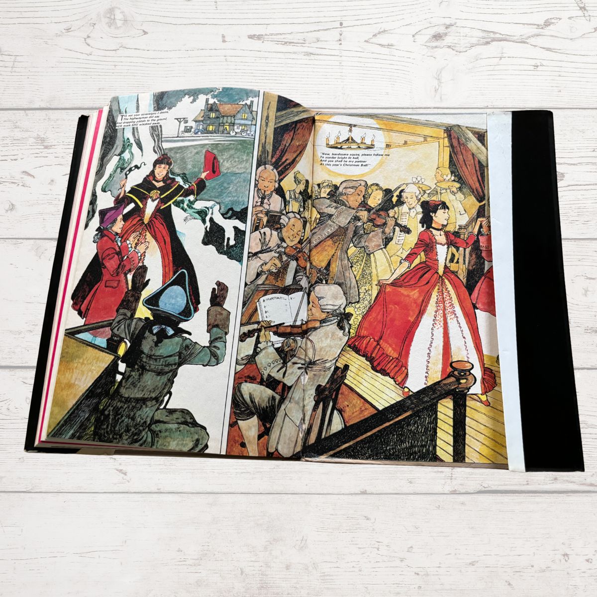 Illustrated book open to a page with colorful characters on a wooden surface