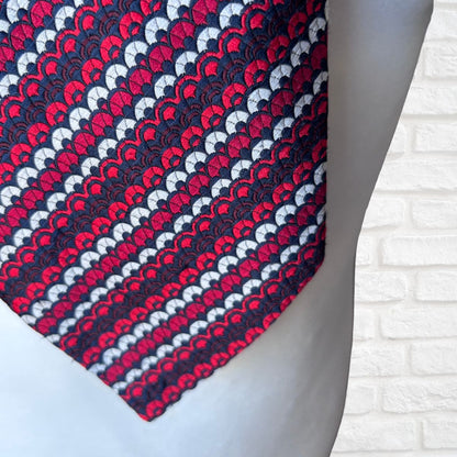 Patterned tie on a mannequin with a white brick wall background