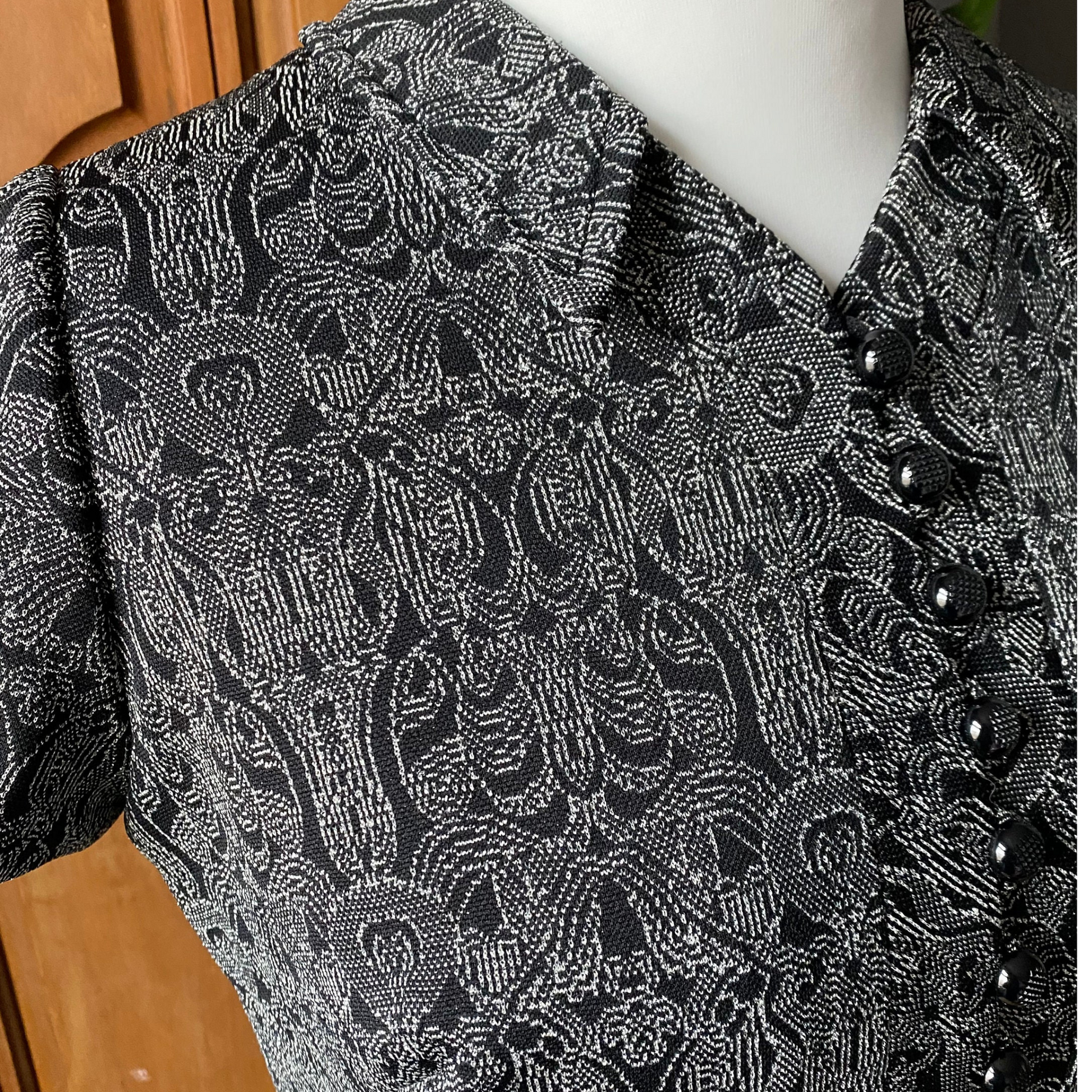 Stylish 60s black mod dress with silver sparkle detail. Black button close up 