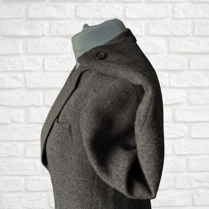 Brown jacket on a mannequin against a white brick wall background