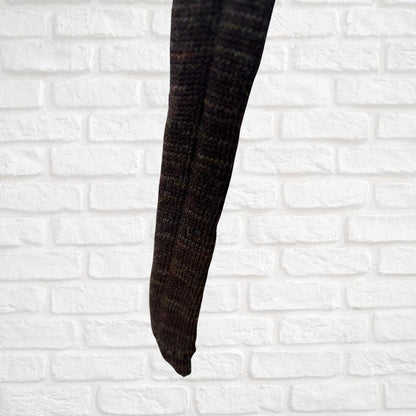 Dark brown tie against a white brick wall background
