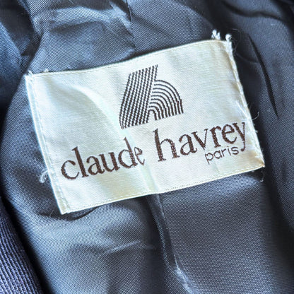 Clothing label with 'claude havrey paris' on a dark fabric background