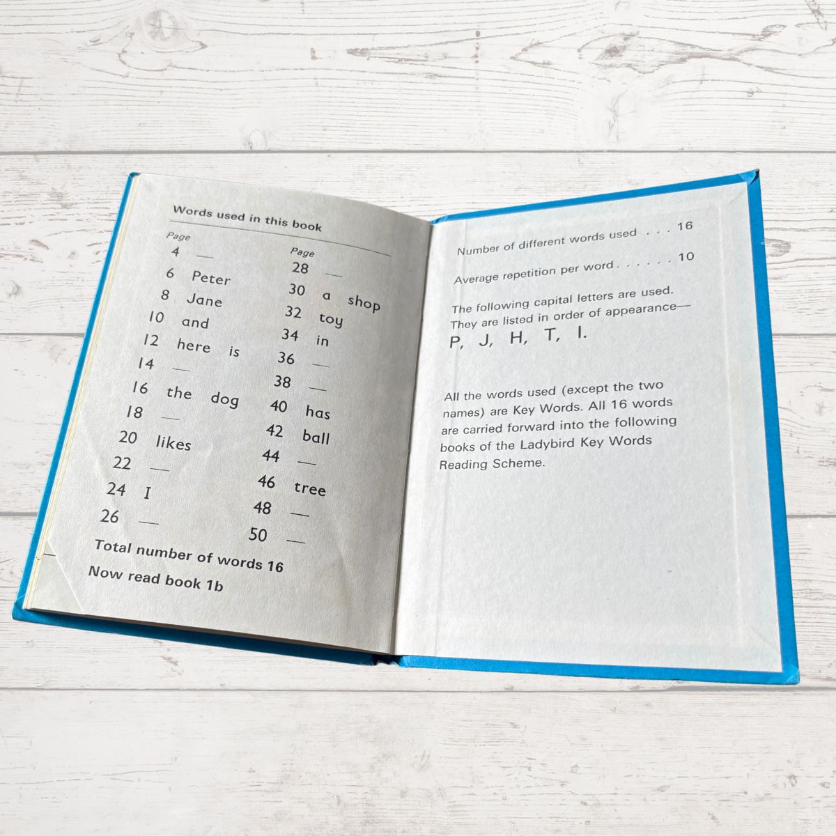 Open book on a wooden surface with text and numbers