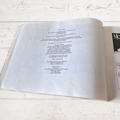 Open book with text on a light wooden surface