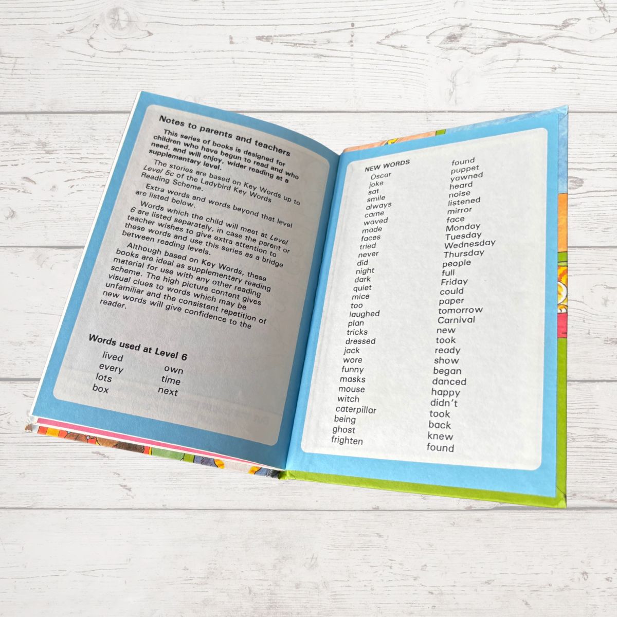 Open book on a wooden surface with text and colorful margins