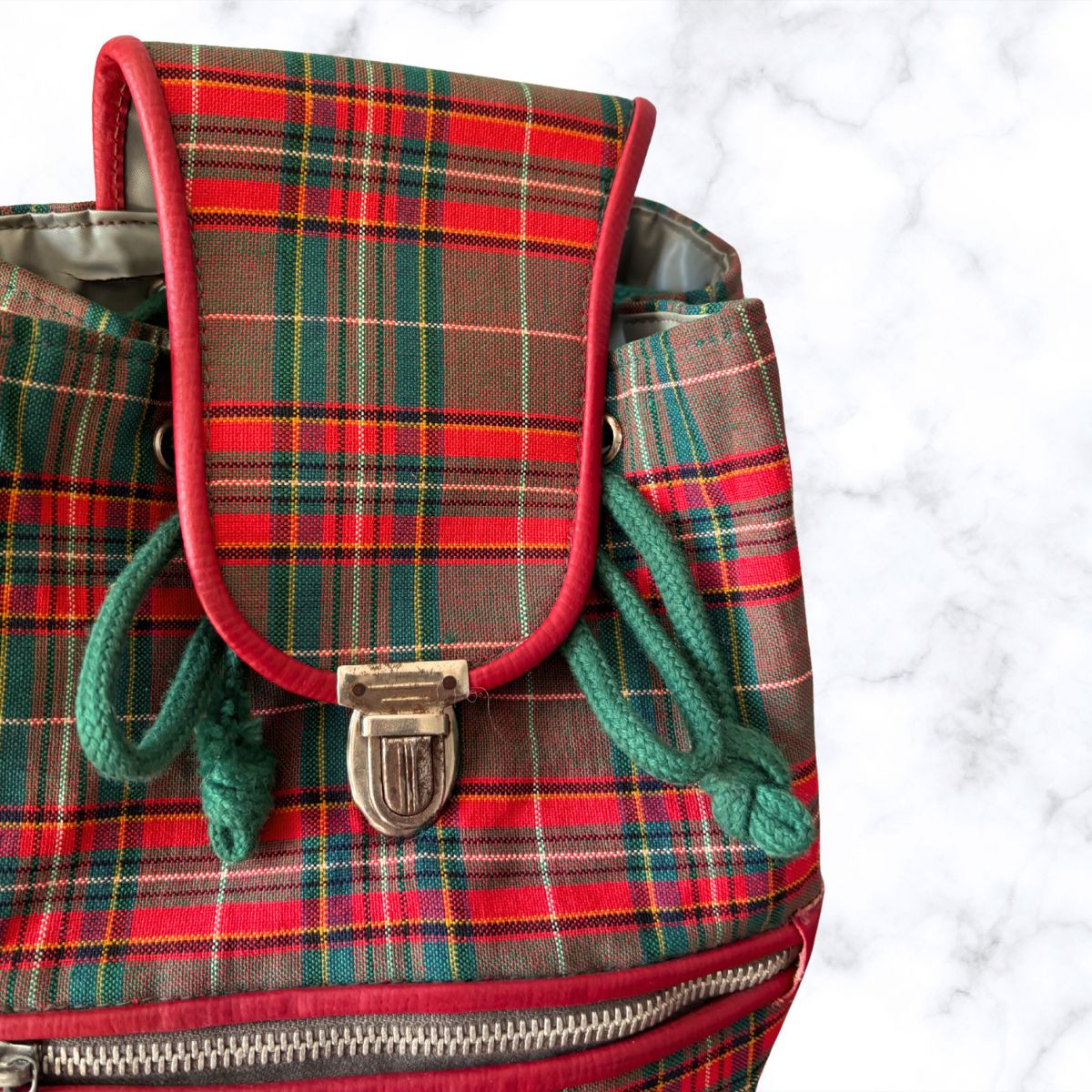 Plaid backpack with a prominent buckle on a white background