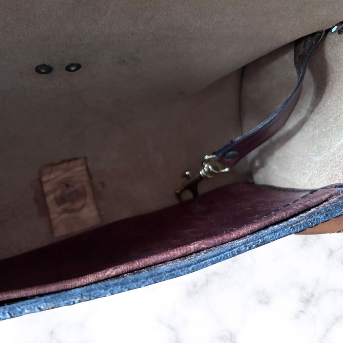 Close-up of the interior of a  bag showing a beige suede-like interior