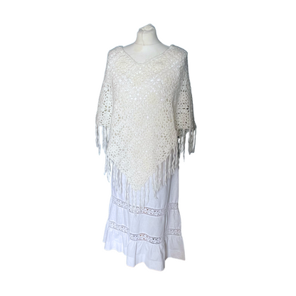 Cream triangular shaped poncho with v neck opening and fringed hem 
