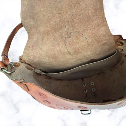 Close-up of inside of leather bag with floral patterns on a white background