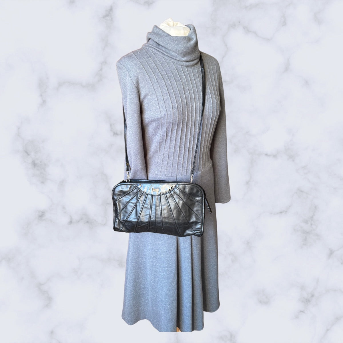 Gray dress with a black  bag on a marble background