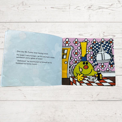 Open book with a colorful illustration of a character and text on a wooden surface