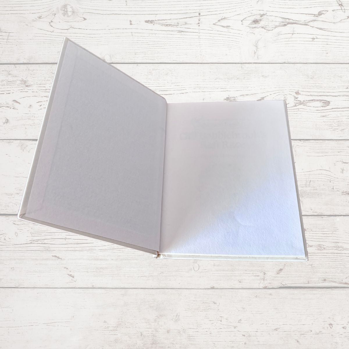 Open notebook with lined pages on a light wooden surface