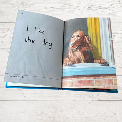 Open book with a dog illustration and text on a wooden surface