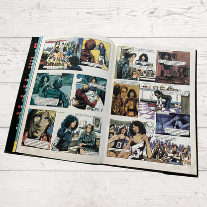 Open comic book with multiple panels on a wooden surface