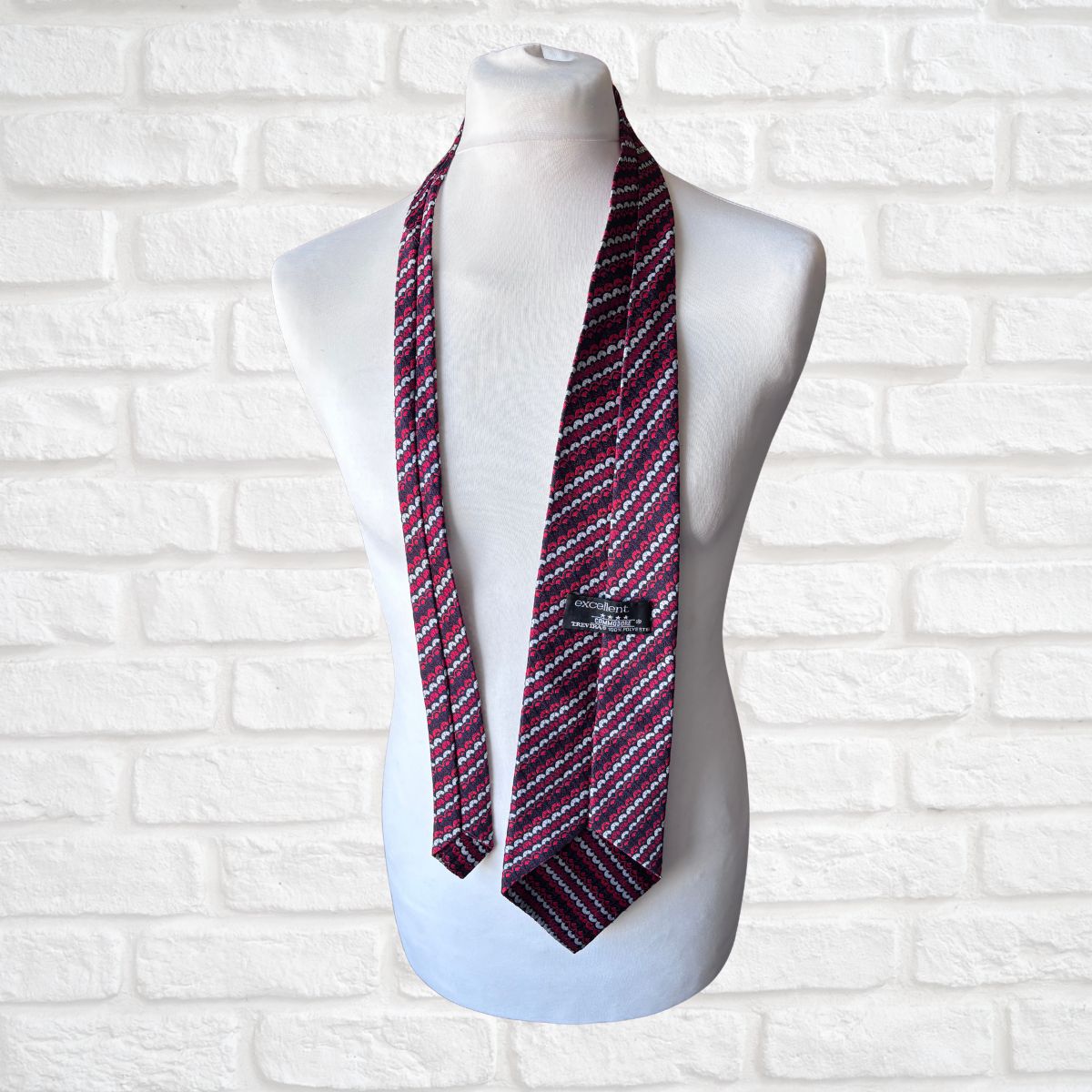 Striped tie on a mannequin against a white brick wall background