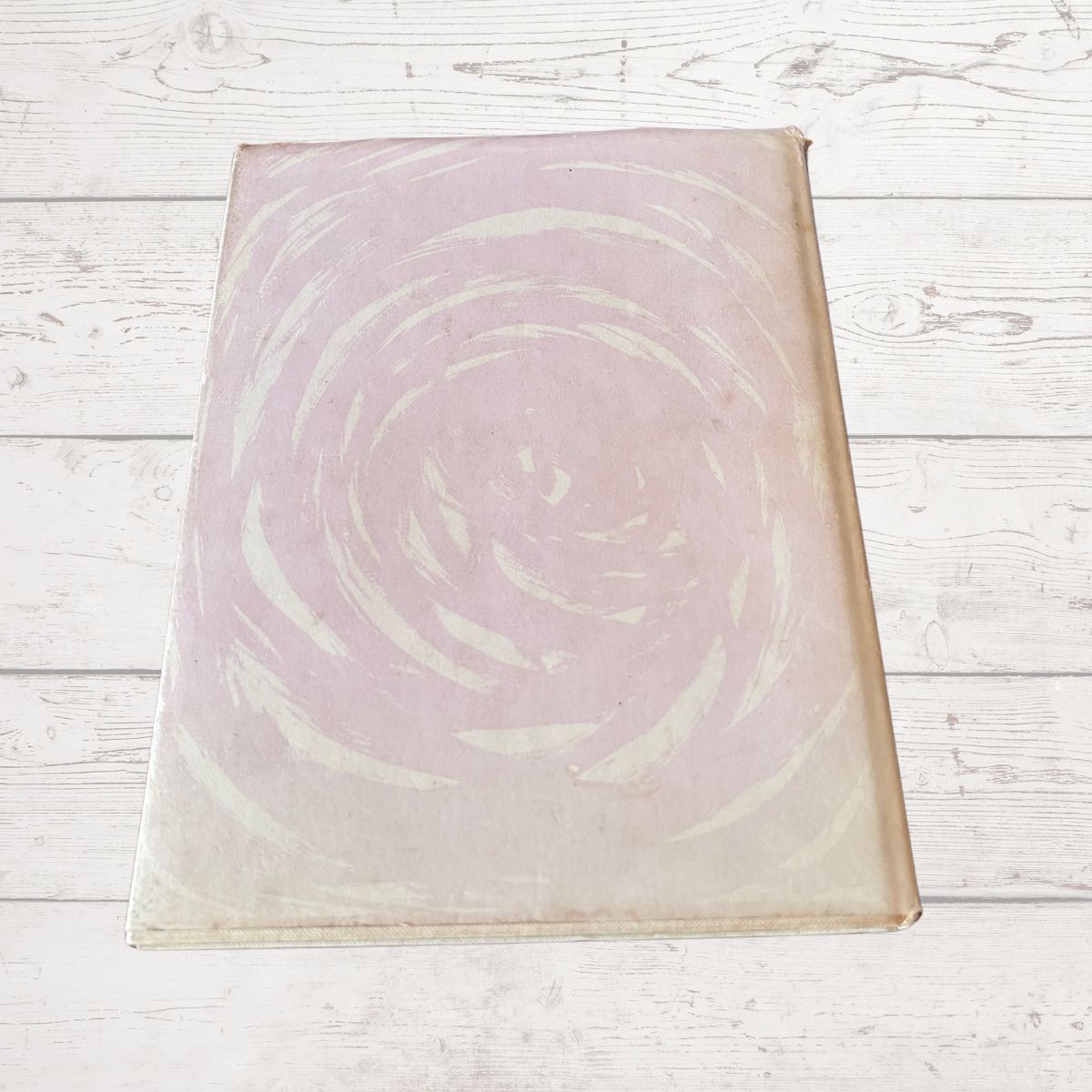 Book cover  with a circular design on a light wooden surface