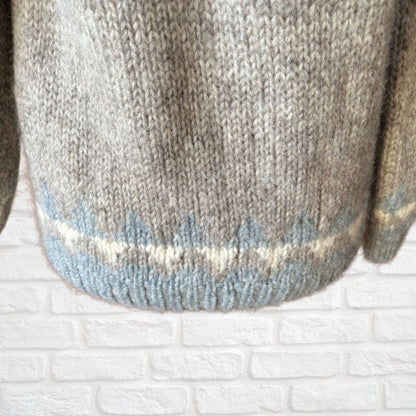 Close-up of a knitted garment with a pattern on a textured white surface