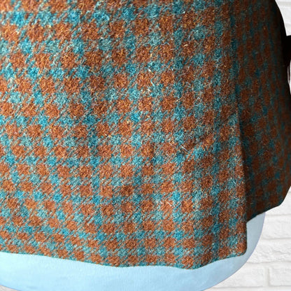 Close-up of a checkered fabric with brown and blue pattern on a white background