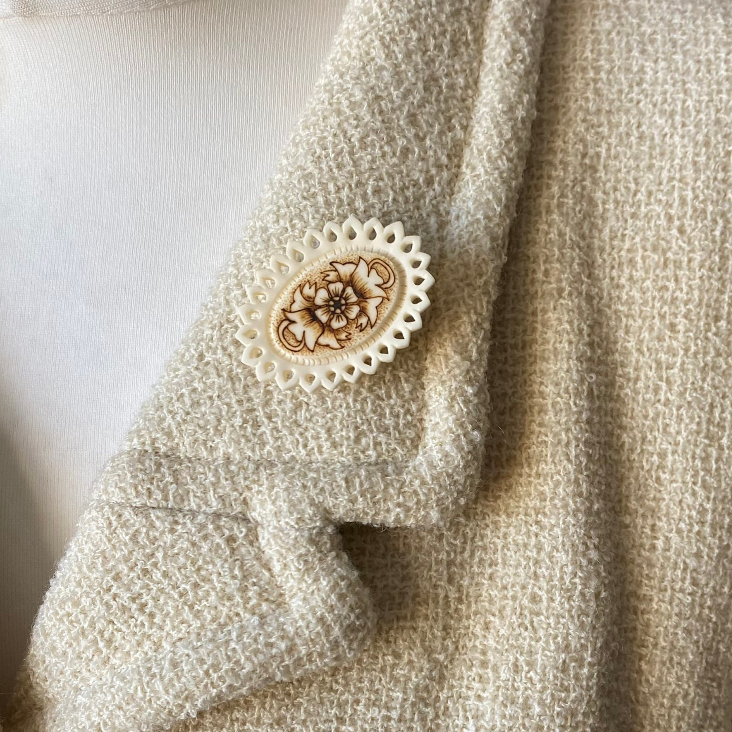 Cream and brown floral brooch on jacket