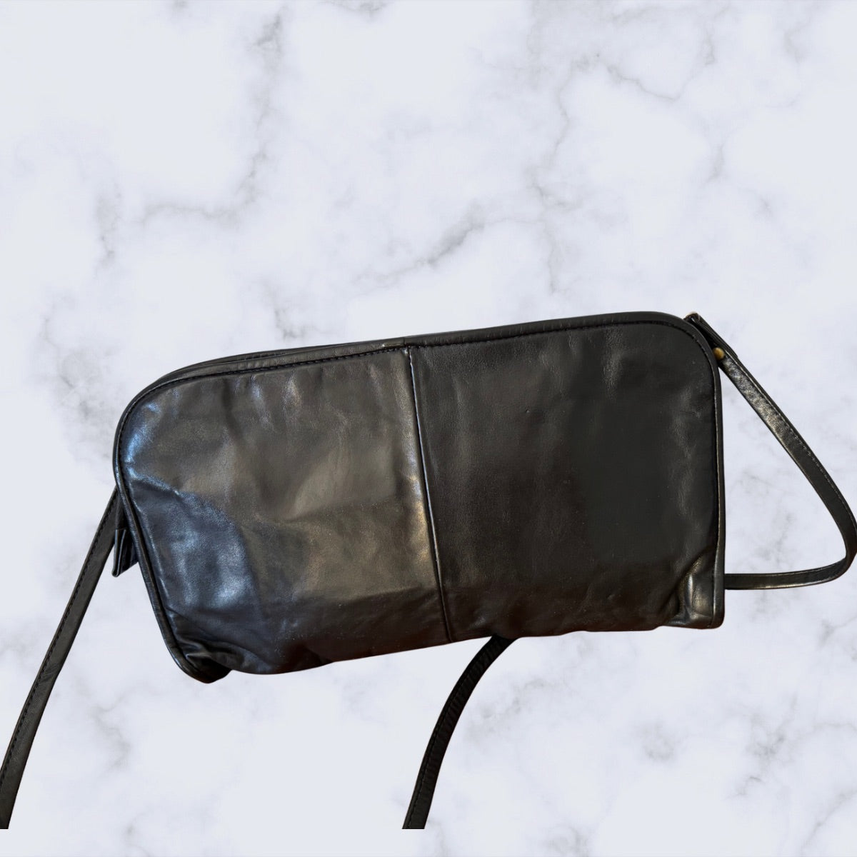Black leather bag on a marble surface