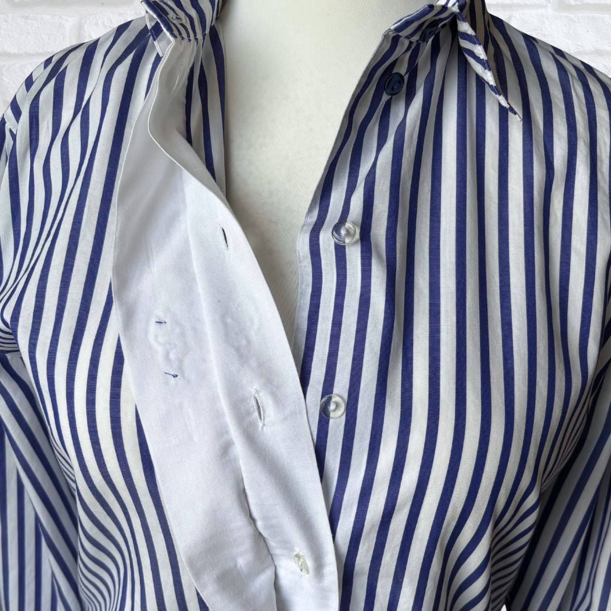 Blue and white striped shirt on a mannequin against a white background