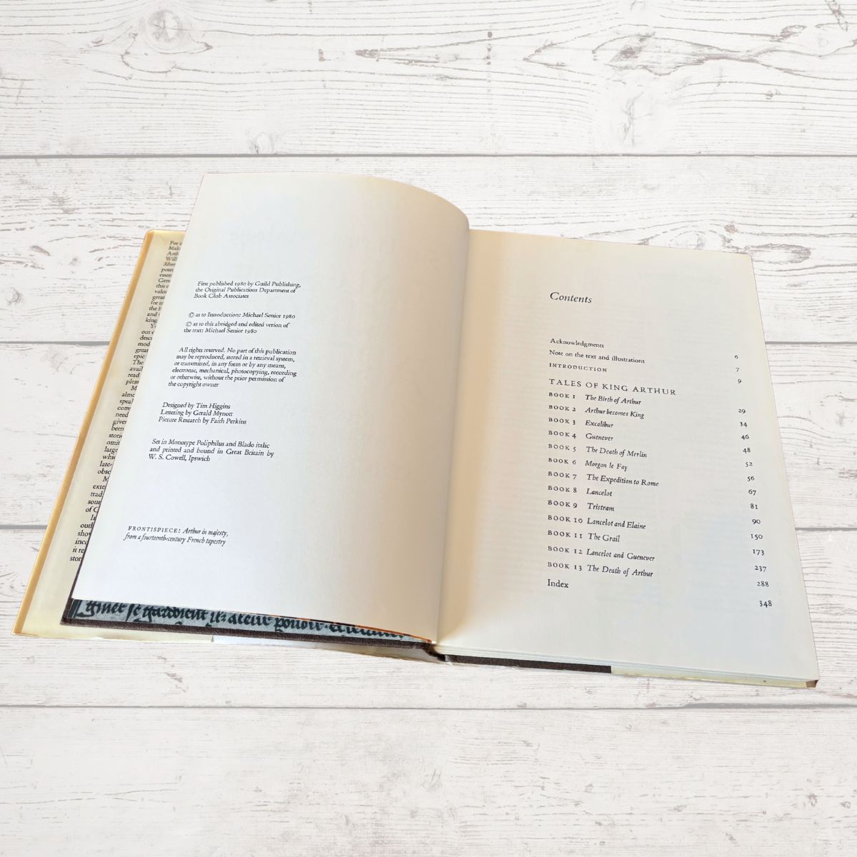 Open book on a wooden surface with text visible