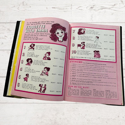 Open book with 'Etiquette with Emma' on a white wooden surface