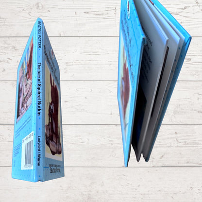 Children's book with blue cover and white pages on a light wooden surface