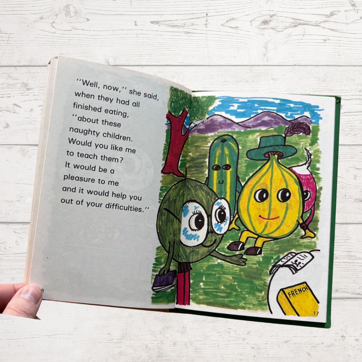 Open book with colorful illustrations of characters on a wooden surface
