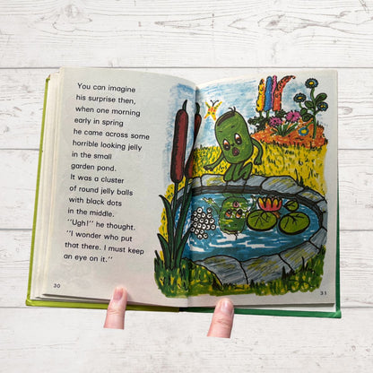 Open book with colorful illustrations of a garden scene and text.