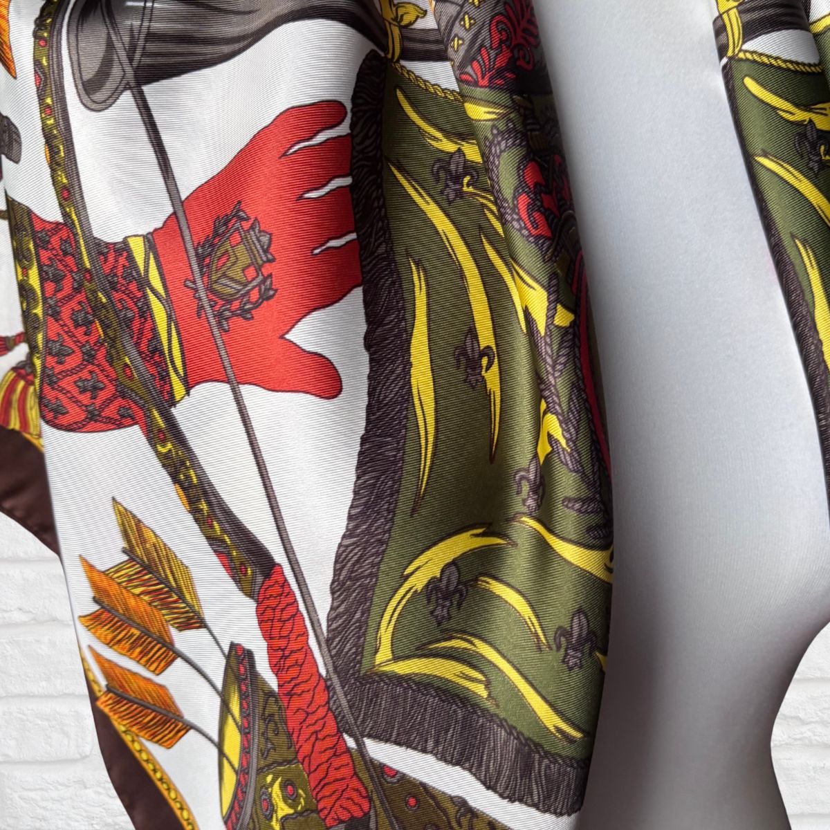 Close-up of a patterned fabric with red, green, and yellow colors on a white background
