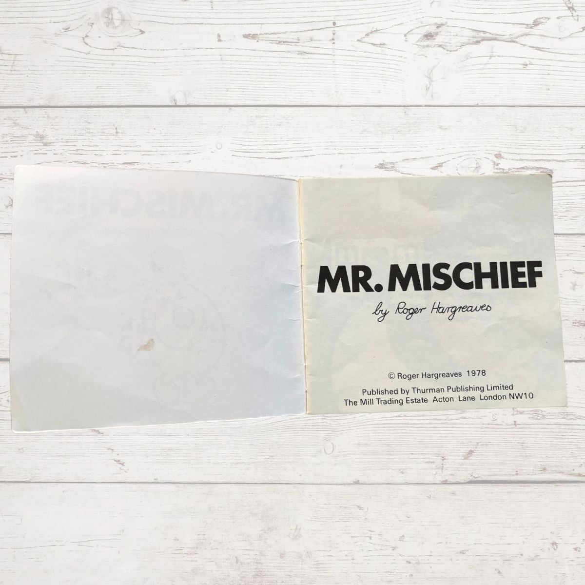 Book titled 'Mr. Mischief' by Roger Hargreaves on a wooden surface