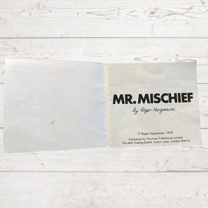 Book titled 'Mr. Mischief' by Roger Hargreaves on a wooden surface