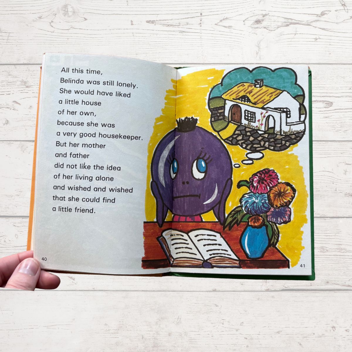 Open book with colorful illustrations and text on a wooden surface