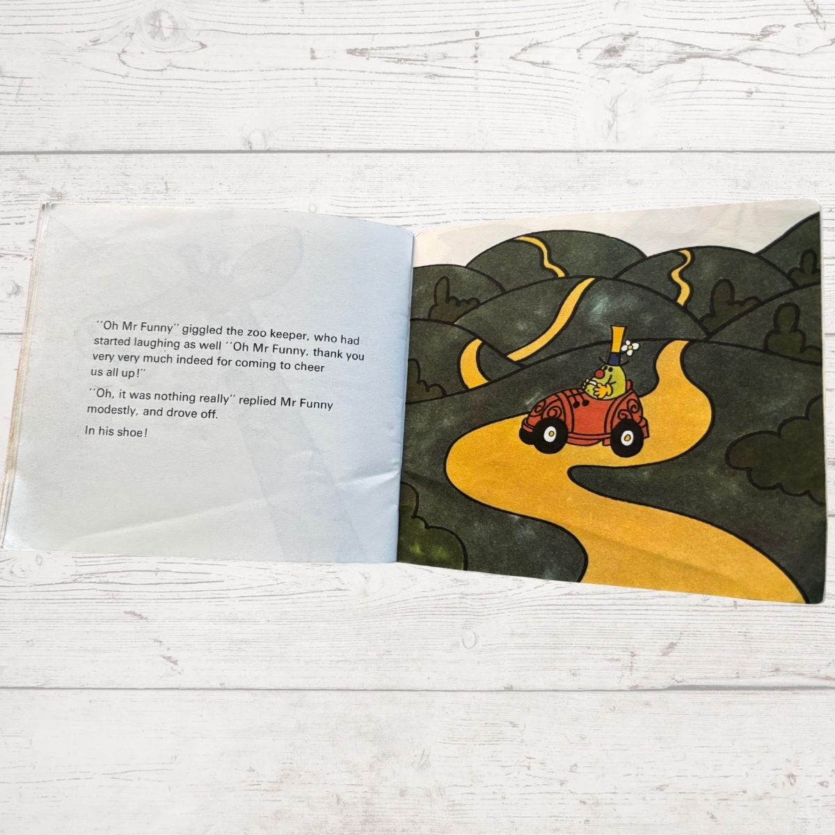 Open book with a cartoon illustration of a car on a winding road.