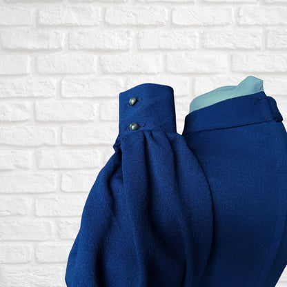 Blue dress deep cuff with buttons on a white brick wall background